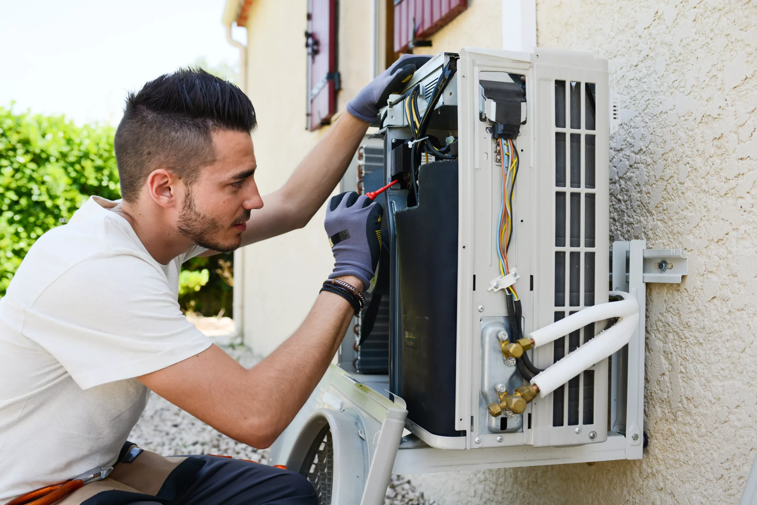 Image illustrates that the man is repairing AC outer shows Air conditioning Repair Kissimmee.