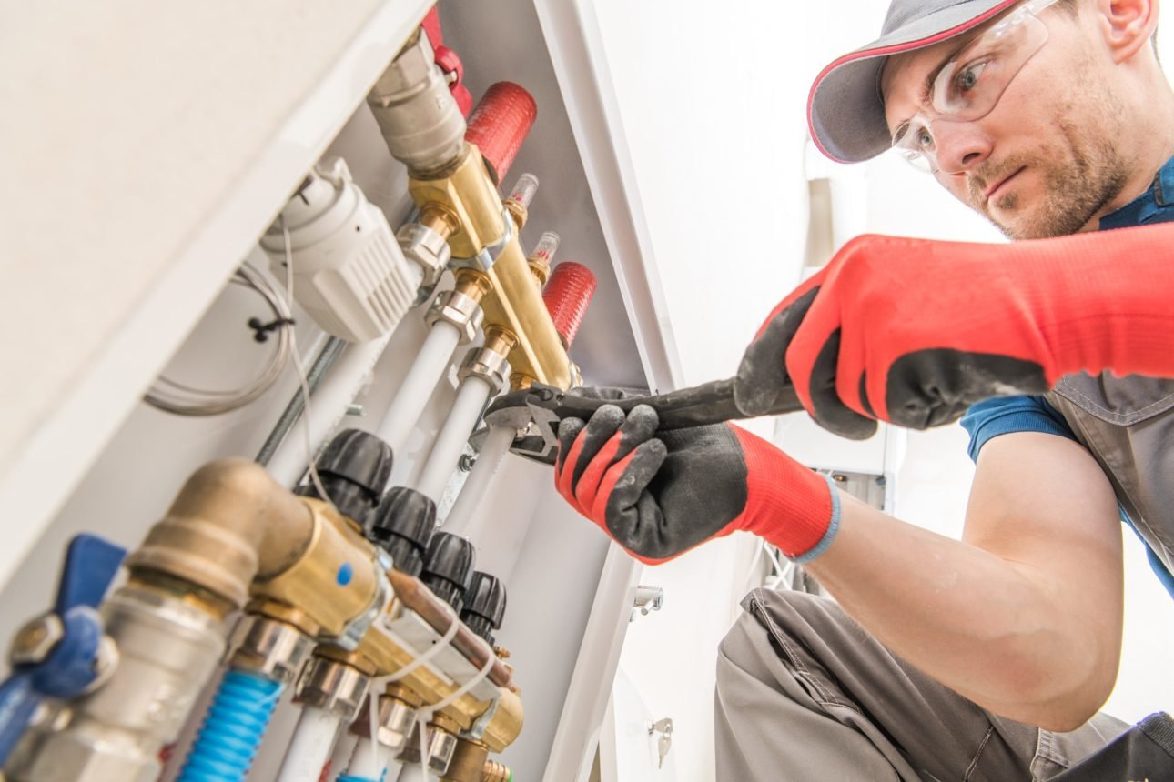 Image illustrates that a man is repairing AC.