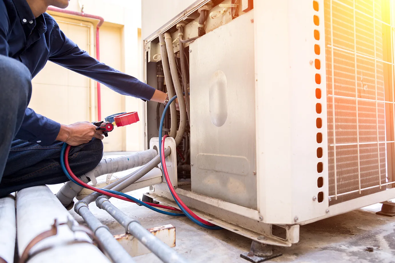 Image illustrates an HVAC contractor is checking Gas pressure in AC outer.